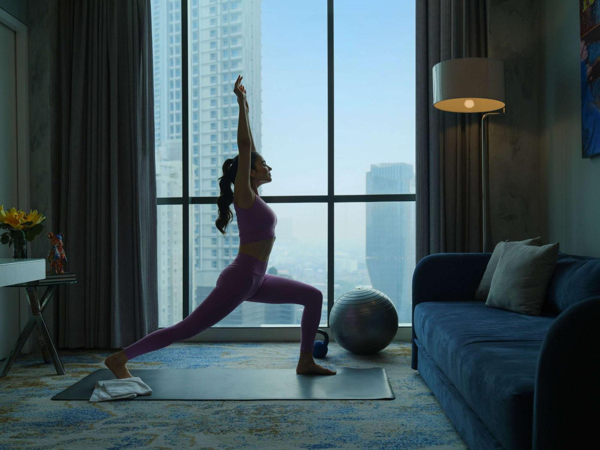 Pullman Jakarta Central Park Εξωτερικό φωτογραφία A woman practicing yoga at home
